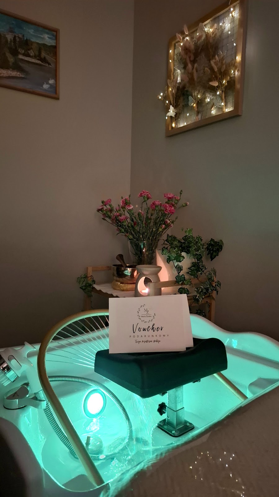 Voucher podarunkowy oparty o misę Head Spa wśród kwiatów