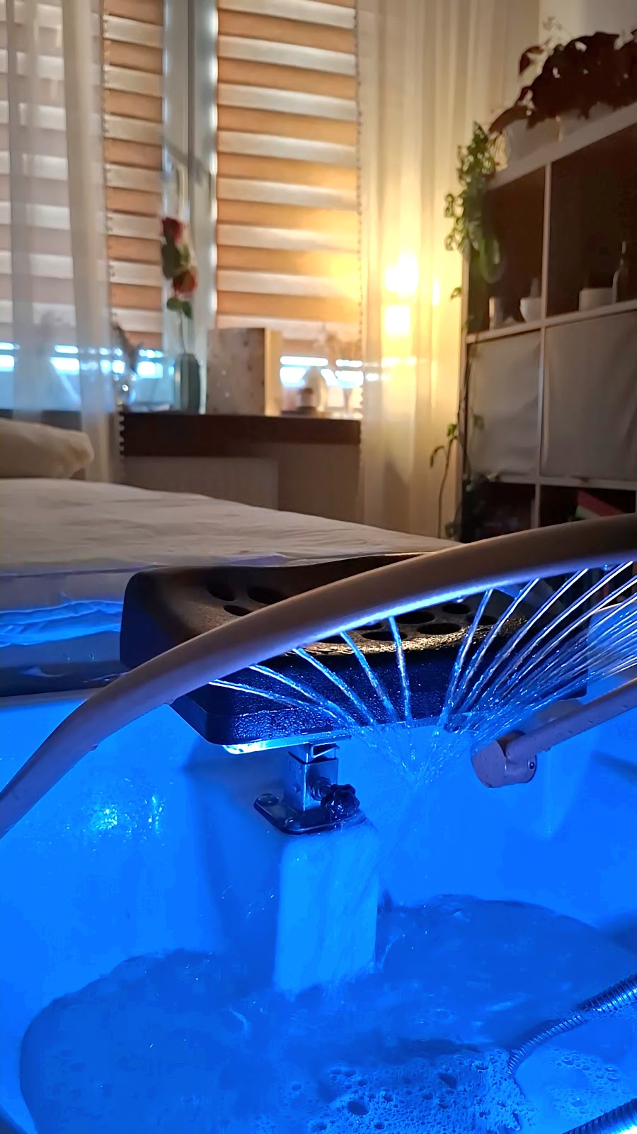 Misa Head Spa w zielonym świetle, kwiaty i świece obok